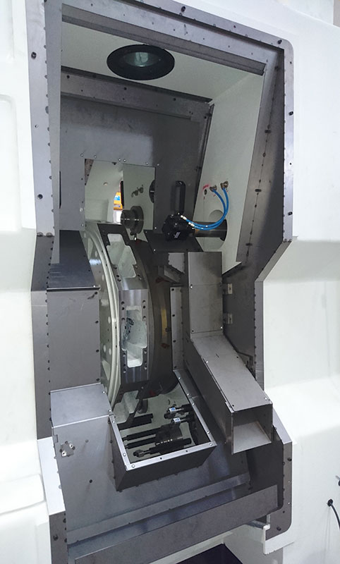 Una vista ravvicinata dell'interno di una macchina CNC industriale, che mostra parti metalliche, cablaggi e componenti meccanici di precisione utilizzati per i processi di lavorazione automatizzati.
