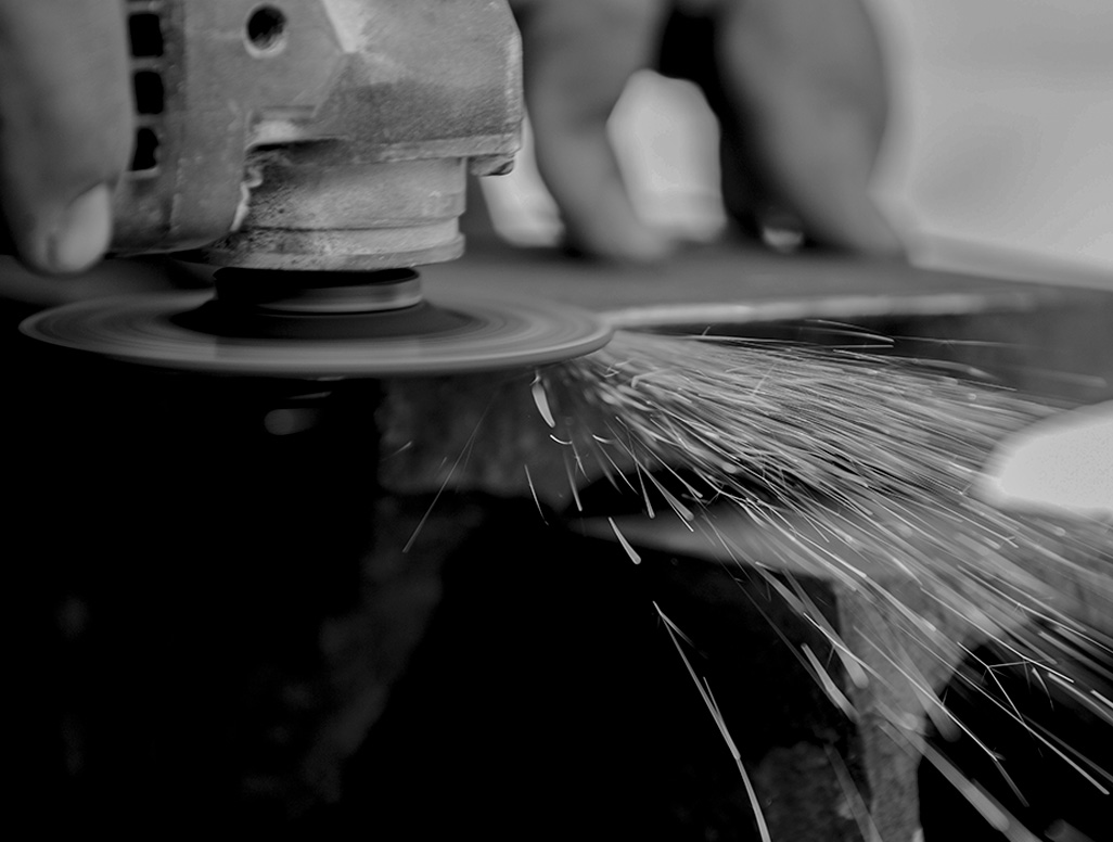 Smerigliatrice in azione con spruzzi di scintille durante lavorazione metallo